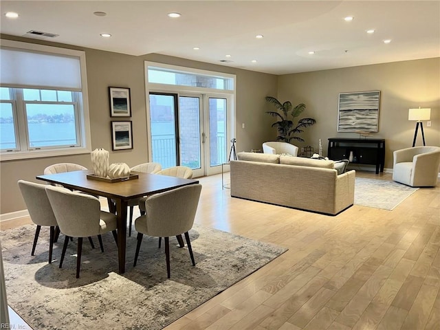 dining area with french doors and light hardwood / wood-style flooring