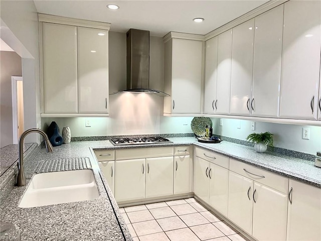 kitchen featuring light tile patterned flooring, sink, stainless steel gas cooktop, and wall chimney range hood