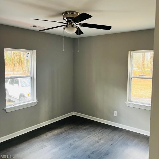 empty room with ceiling fan and dark wood-type flooring