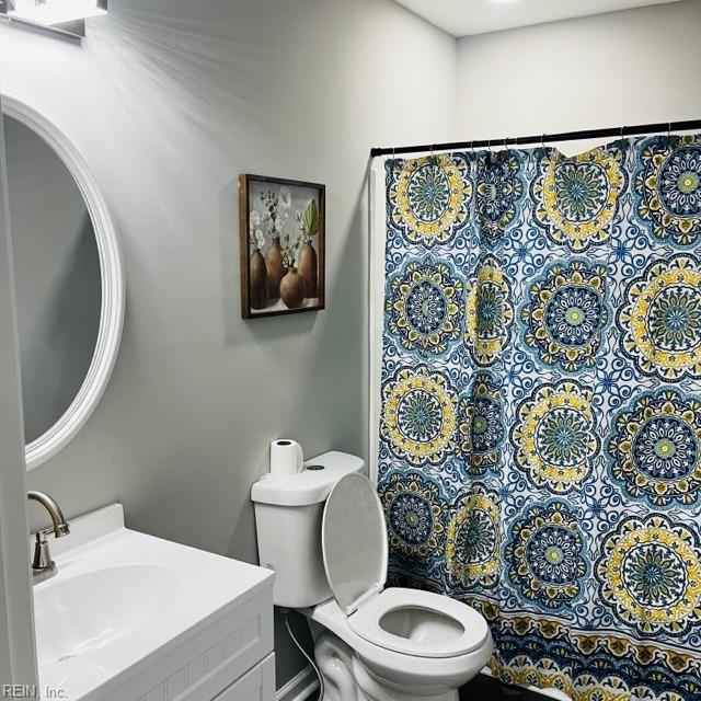 bathroom with a shower with curtain, vanity, and toilet