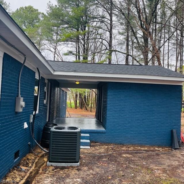 view of side of home featuring central AC and a carport