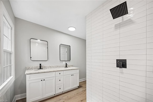 bathroom featuring hardwood / wood-style flooring, vanity, and a shower