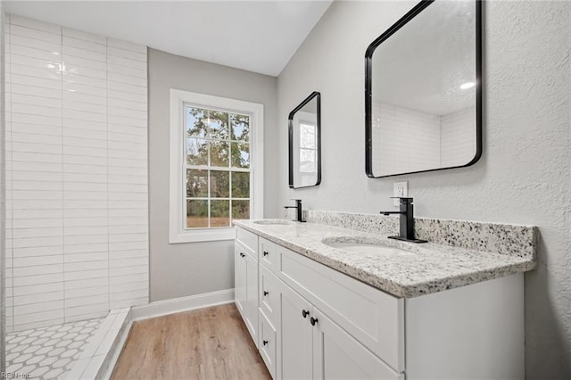 bathroom featuring wood-type flooring, vanity, and walk in shower