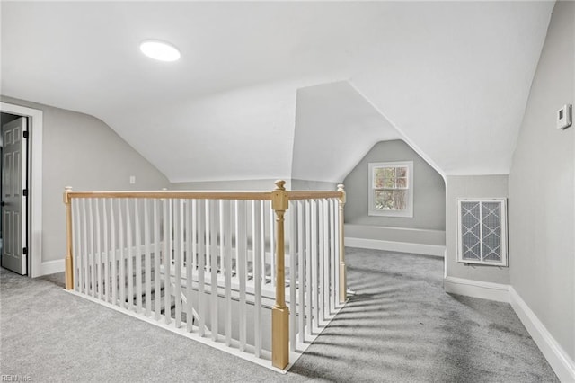 additional living space featuring light colored carpet and vaulted ceiling