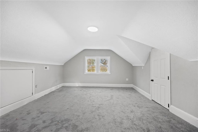 additional living space with carpet flooring and vaulted ceiling