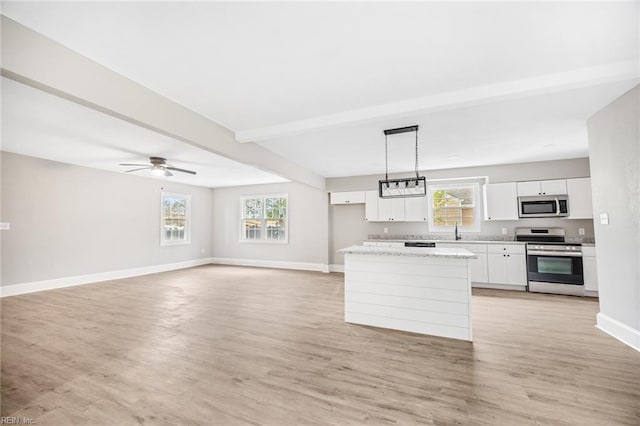 kitchen with hanging light fixtures, white cabinets, a healthy amount of sunlight, and appliances with stainless steel finishes