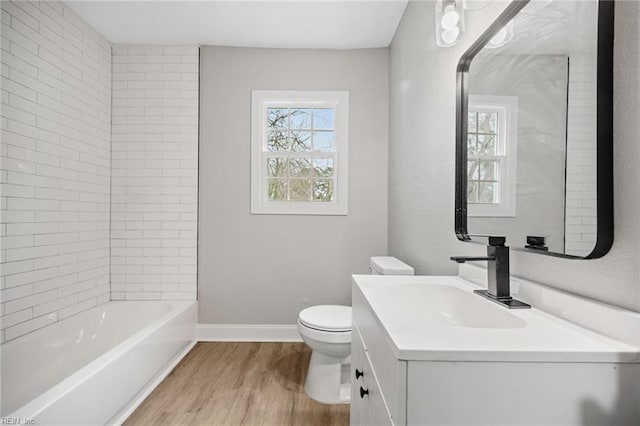 full bathroom featuring hardwood / wood-style floors, vanity, toilet, and tiled shower / bath