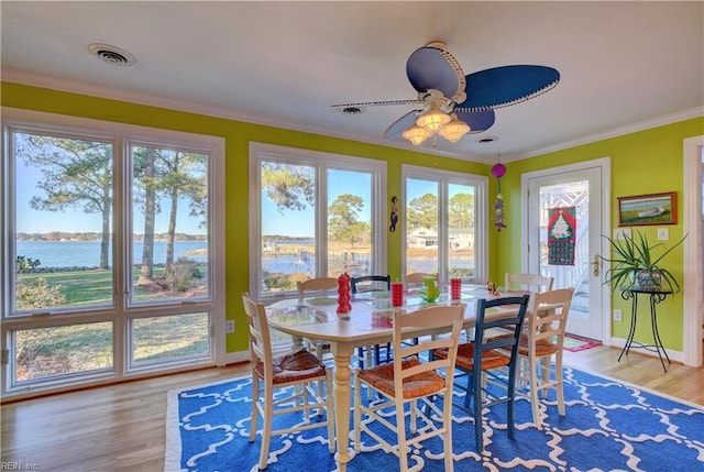 sunroom / solarium featuring a water view, a wealth of natural light, and ceiling fan