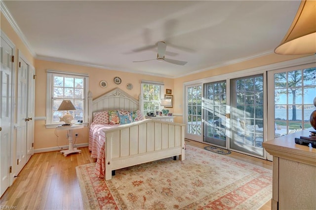 bedroom featuring access to exterior, ceiling fan, crown molding, a water view, and light hardwood / wood-style floors