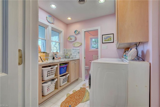 laundry area featuring cabinets, independent washer and dryer, light tile patterned floors, and plenty of natural light