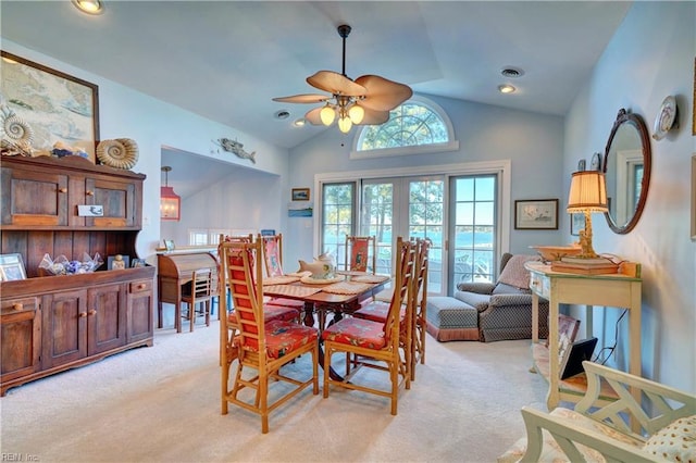 carpeted dining area featuring ceiling fan, french doors, and lofted ceiling