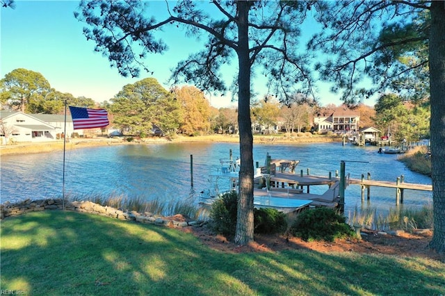 dock area with a yard and a water view