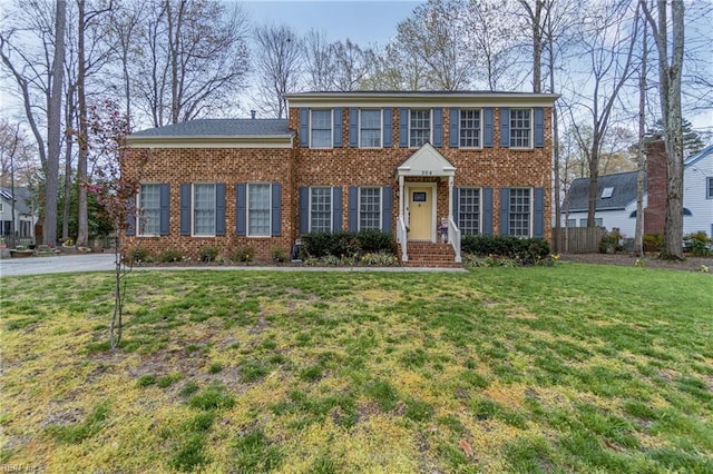 colonial-style house featuring a front yard