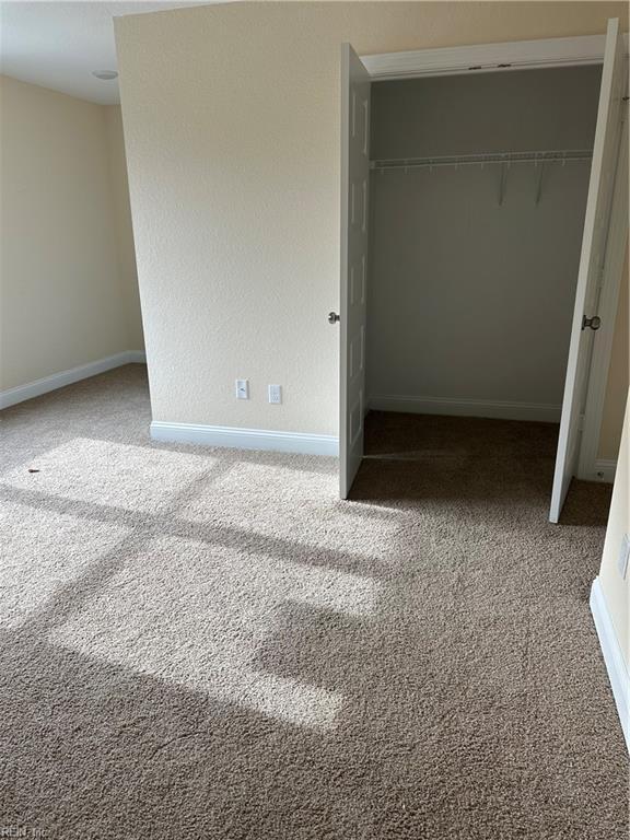 unfurnished bedroom featuring carpet floors and a closet