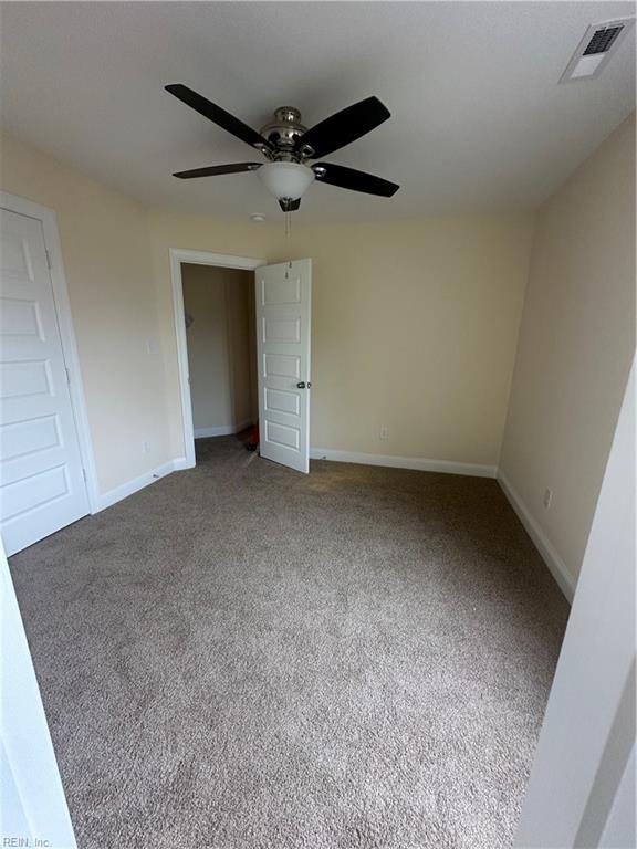 unfurnished bedroom featuring ceiling fan, a closet, and carpet floors