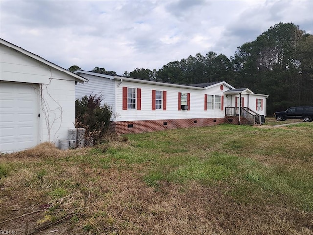 manufactured / mobile home with a garage and a front yard