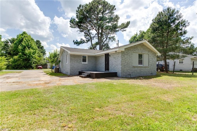 rear view of property featuring a lawn