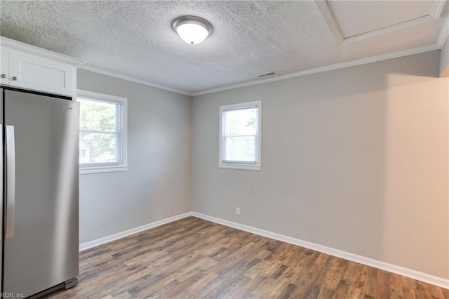 unfurnished room featuring crown molding, hardwood / wood-style floors, and a textured ceiling