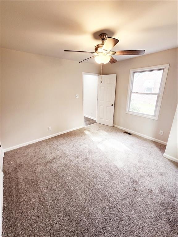 carpeted empty room featuring ceiling fan