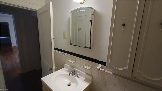 bathroom with vanity and tile walls