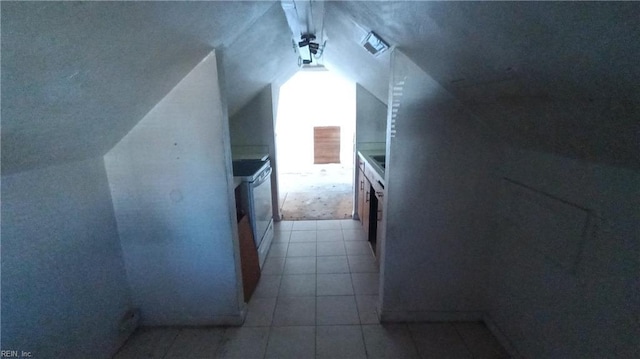 interior space with light tile patterned floors and vaulted ceiling