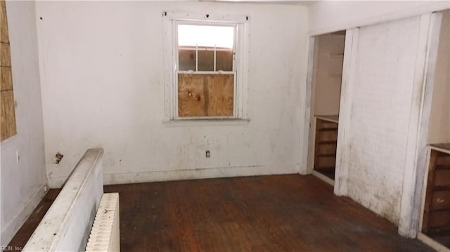 spare room with radiator and dark hardwood / wood-style flooring