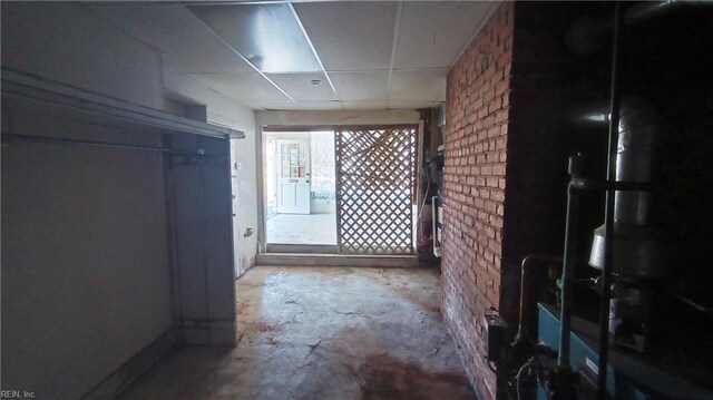 corridor featuring brick wall and concrete floors