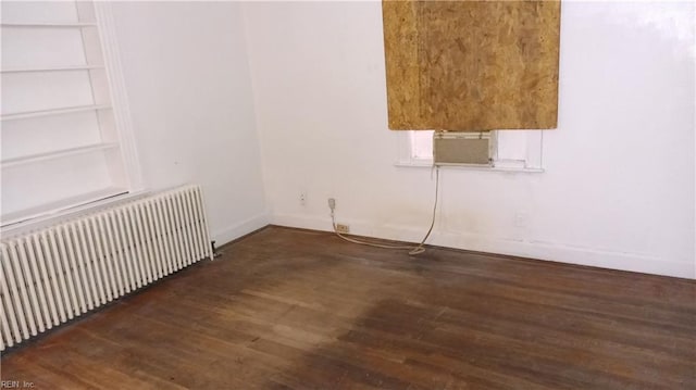 empty room with radiator, dark hardwood / wood-style flooring, and cooling unit