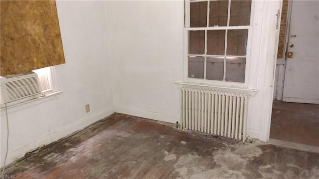 empty room featuring radiator and dark hardwood / wood-style flooring