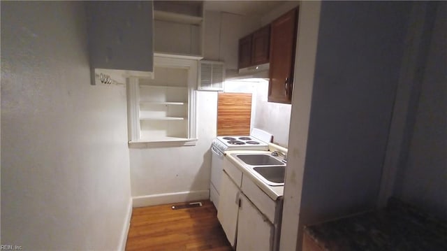 kitchen with electric range, light hardwood / wood-style floors, white cabinetry, and sink