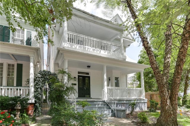 view of front of house with french doors, a balcony, and a porch