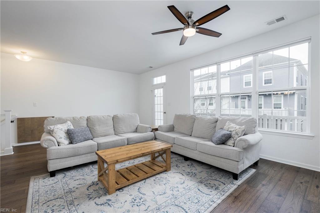 living room with ceiling fan, dark wood-type flooring, and a wealth of natural light