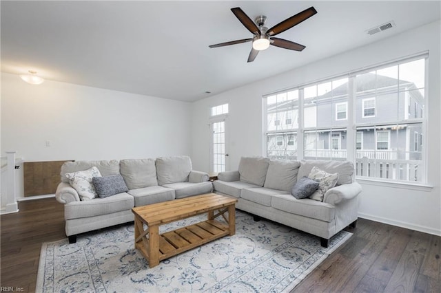 living room with ceiling fan, dark wood-type flooring, and a wealth of natural light