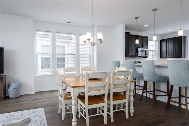 dining room with dark hardwood / wood-style floors and a notable chandelier