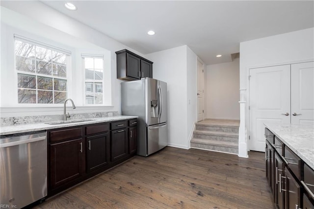 kitchen featuring dark hardwood / wood-style flooring, light stone countertops, sink, and appliances with stainless steel finishes