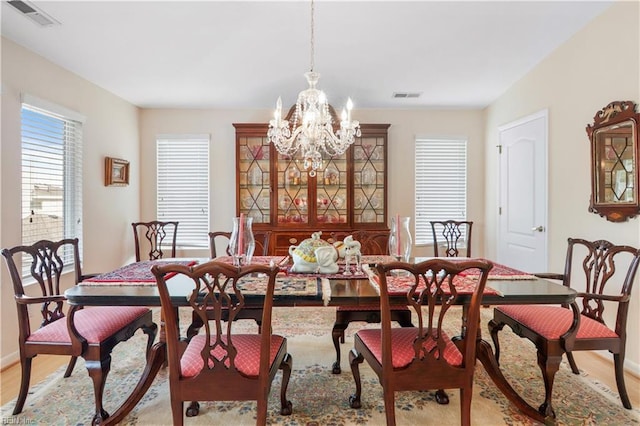 dining area featuring light hardwood / wood-style floors and an inviting chandelier