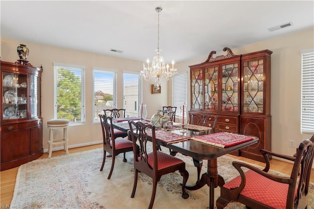 dining area featuring light hardwood / wood-style flooring and a notable chandelier