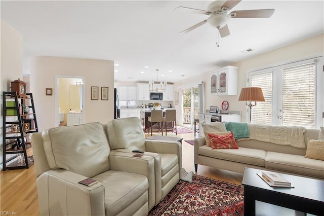 living room with ceiling fan and light hardwood / wood-style flooring