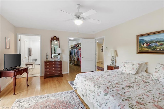 bedroom featuring ceiling fan, a closet, a spacious closet, and light hardwood / wood-style flooring