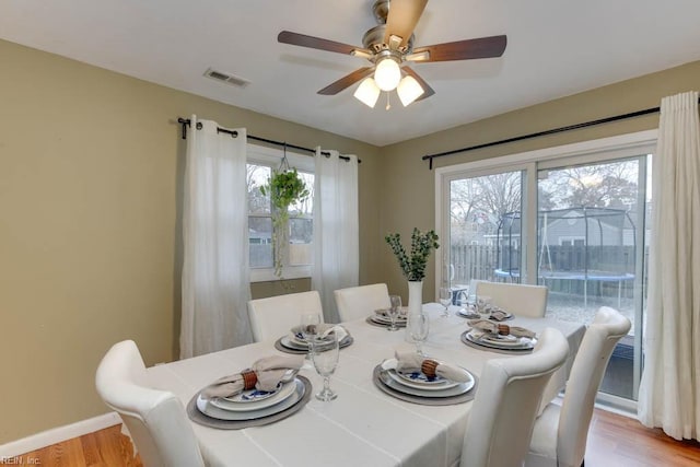 dining area with ceiling fan and light wood-type flooring