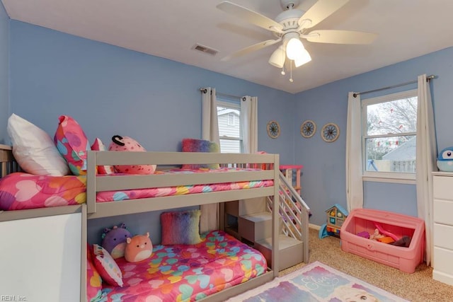 bedroom featuring carpet flooring, ceiling fan, and multiple windows