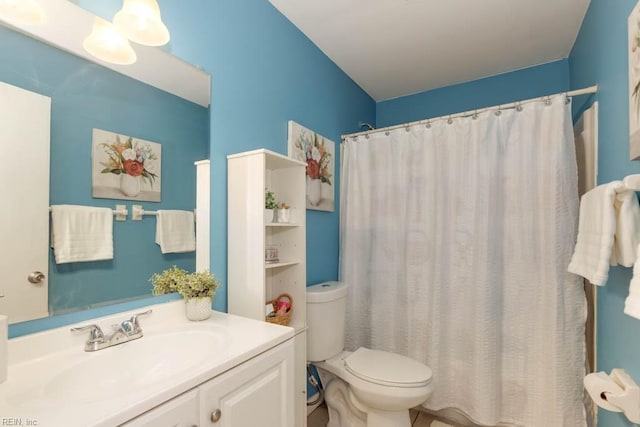 bathroom with walk in shower, vanity, and toilet