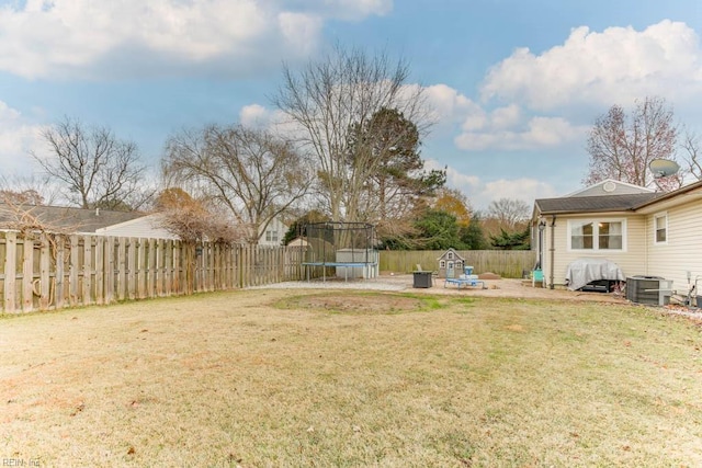 view of yard with central air condition unit, a patio area, and a trampoline