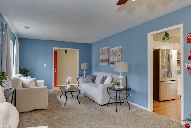 carpeted living room featuring ceiling fan