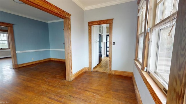 empty room featuring radiator heating unit, ornamental molding, and dark wood-type flooring