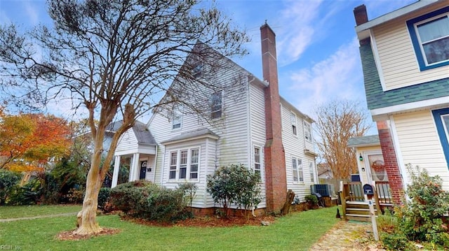 view of property exterior featuring a lawn and central AC