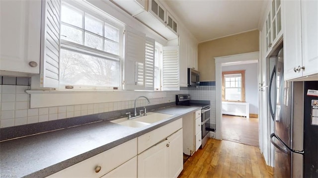 kitchen featuring sink, white cabinets, stainless steel appliances, and light hardwood / wood-style flooring