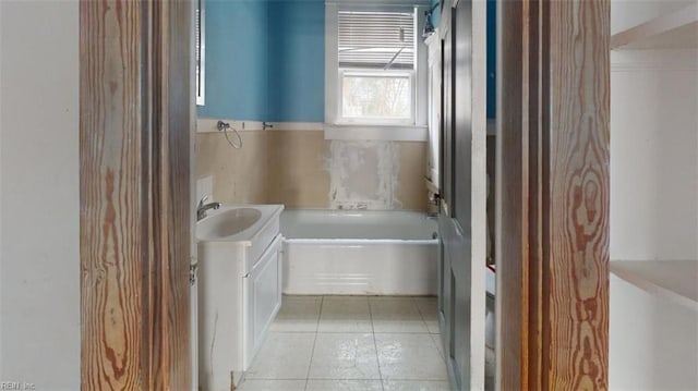 bathroom with a bath, vanity, and tile patterned floors