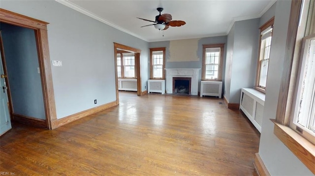 unfurnished living room with plenty of natural light, dark hardwood / wood-style flooring, and radiator