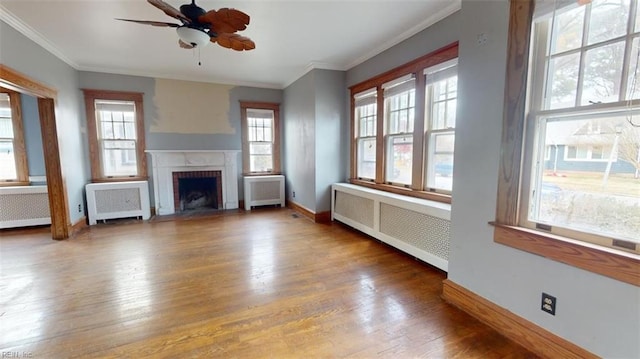 unfurnished living room featuring a wealth of natural light and radiator